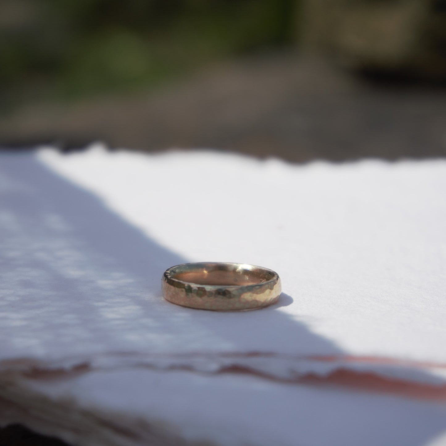 Simple textured 9ct yellow gold wedding band photographed on white in Northern Ireland.