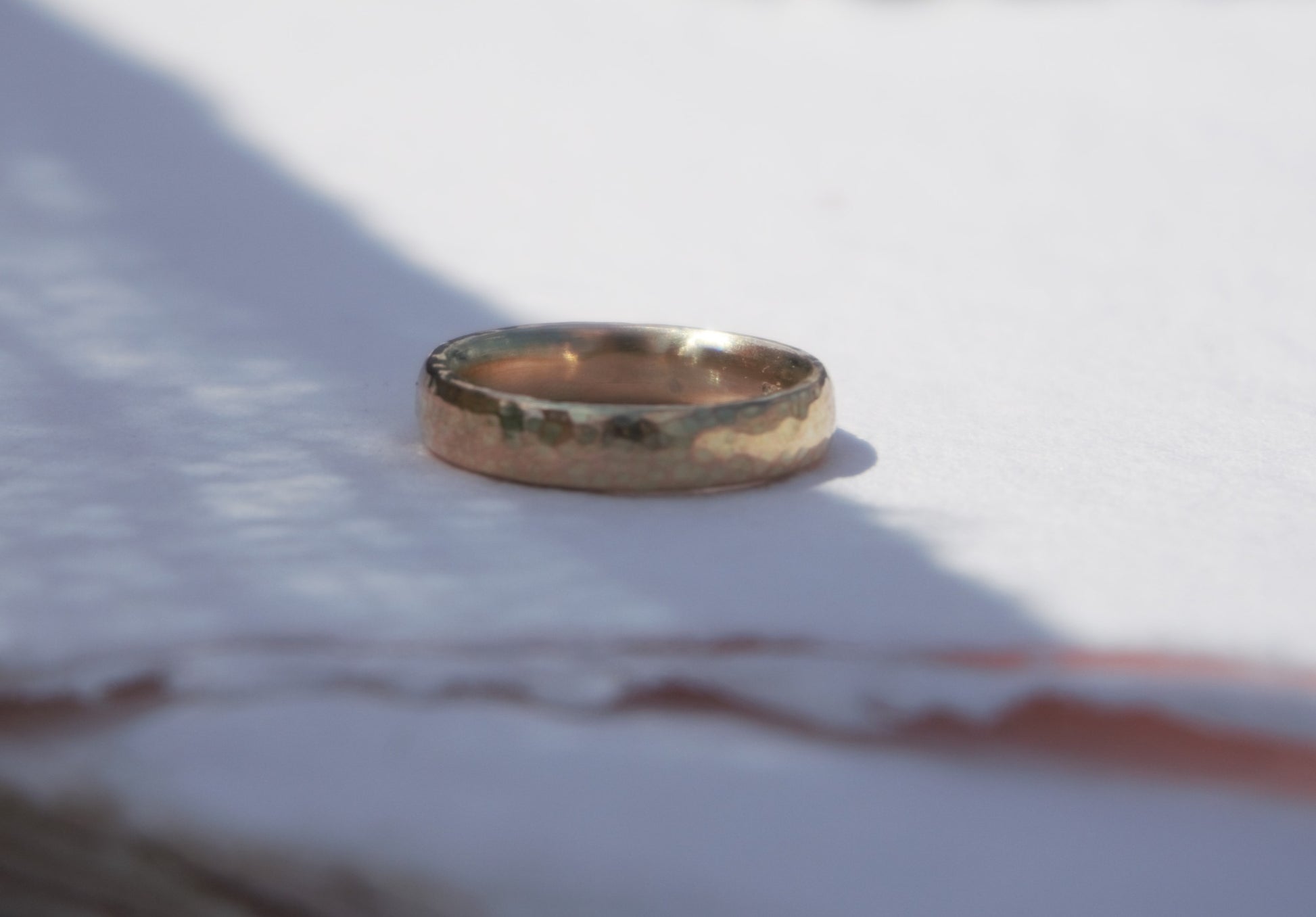 simple and textured handmade 9ct yellow gold wedding band pictured on white in Northern Ireland.