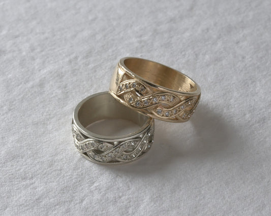 Celtic style gold and diamond eternity rings, stacked together. \pictured on white.