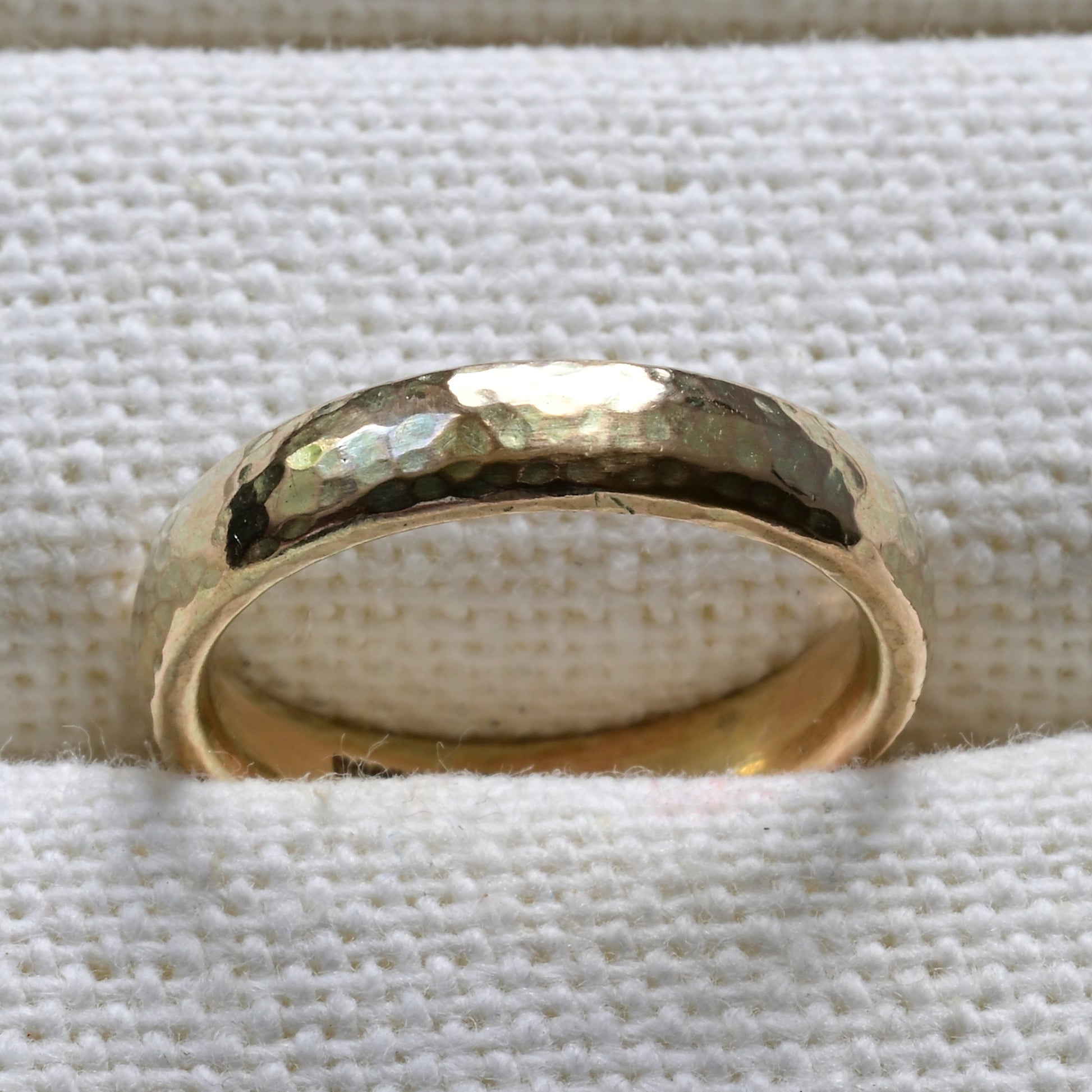 simple 9ct yellow gold wedding band pictured on a white background.