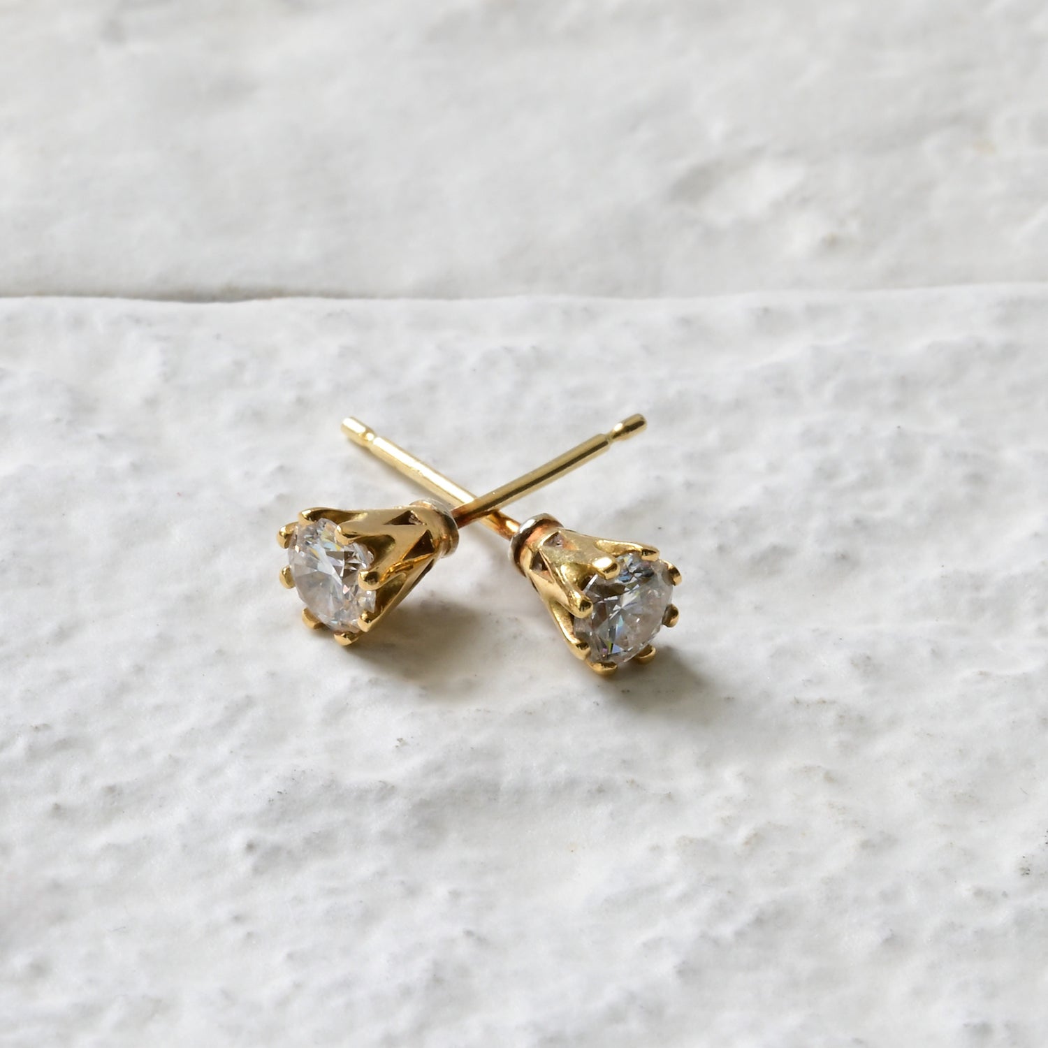 18ct yellow gold and diamond studs, photographed on white brick. Handmade fine jewellery Madeleine