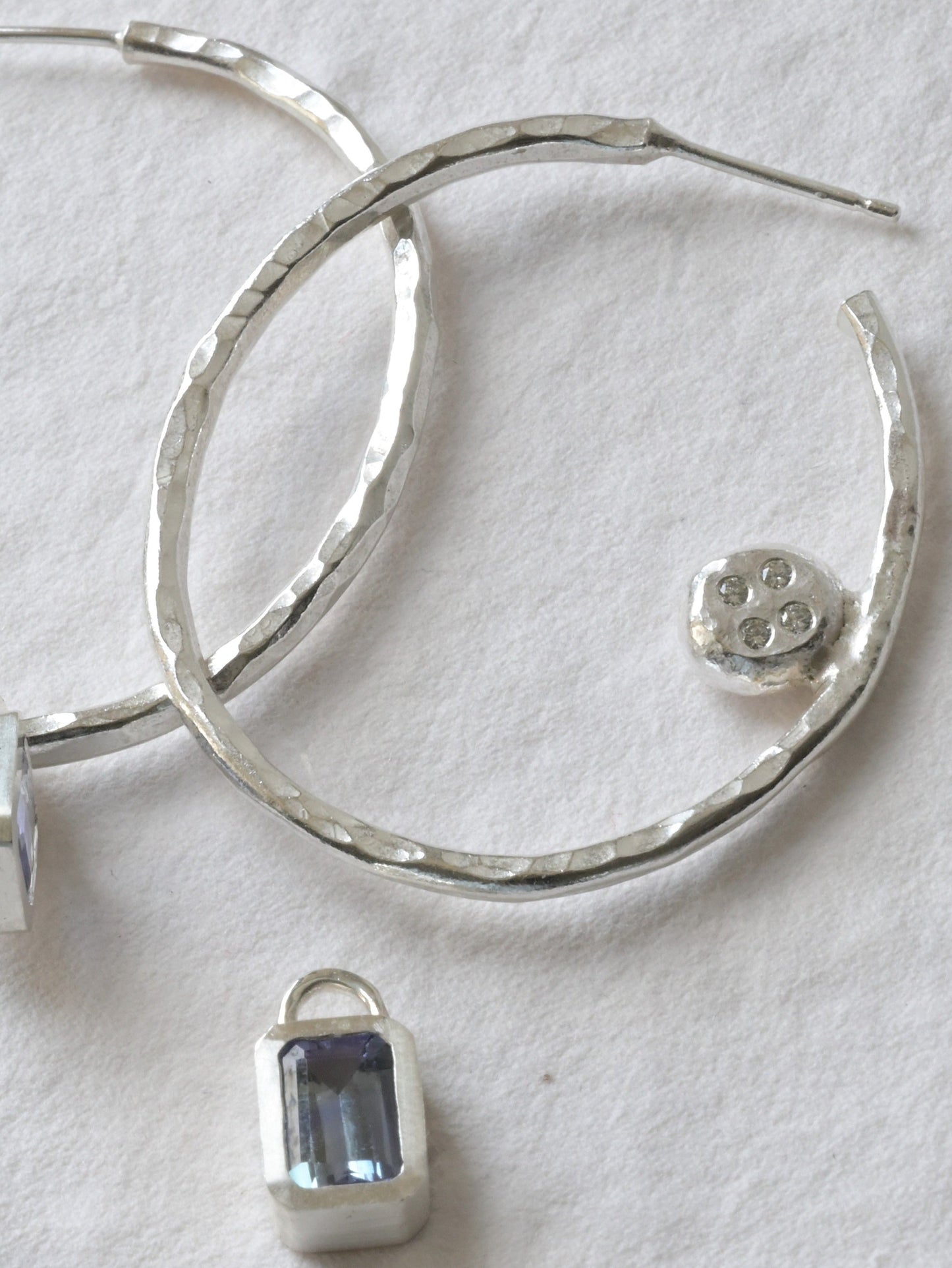 handmade sterling silver hoops with diamonds and tanzanite's photographed on white. Handmade fine jewellery by Madeleine.