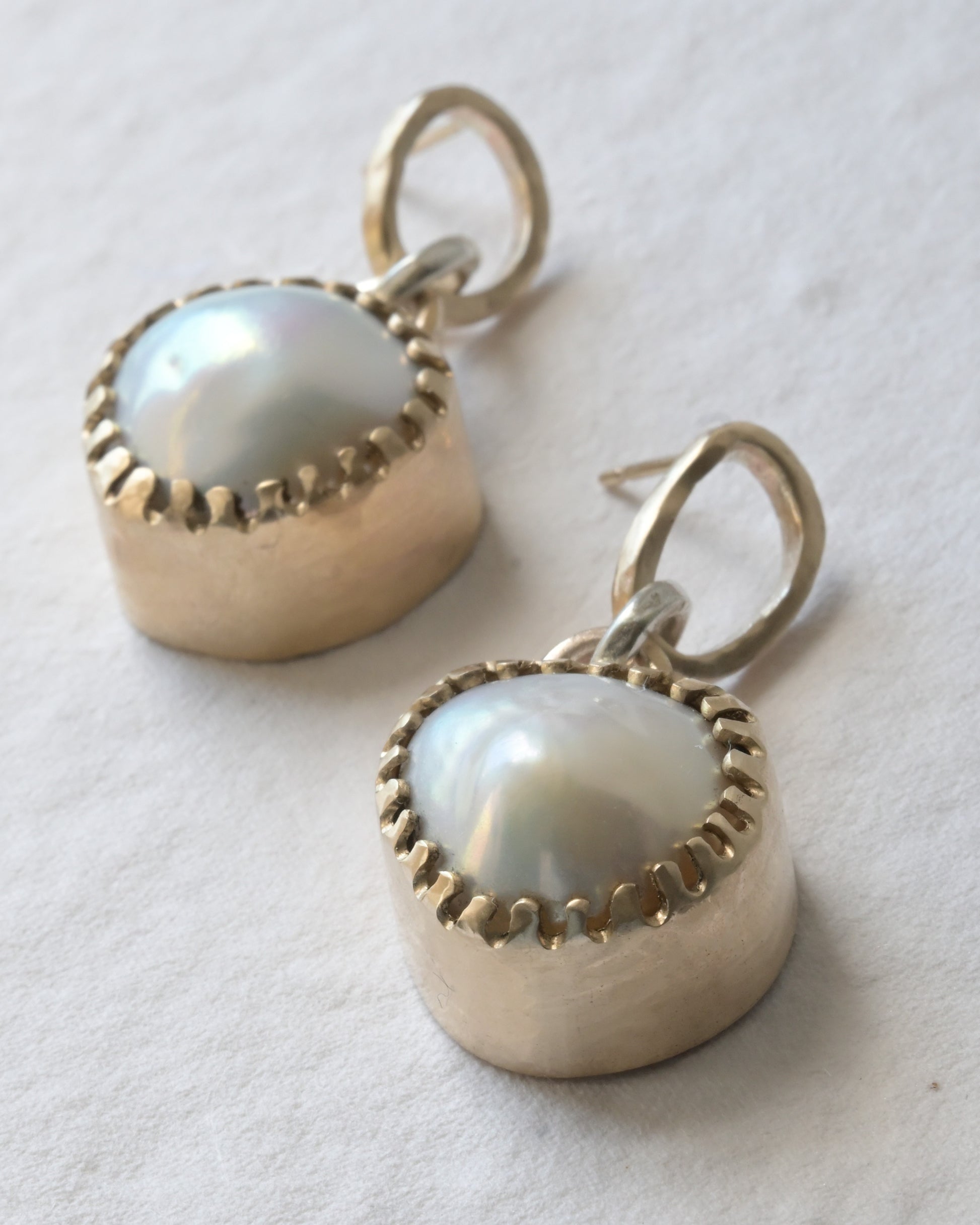 very large 9ct yellow gold baroque pearl earrings placed on cotswold stone.