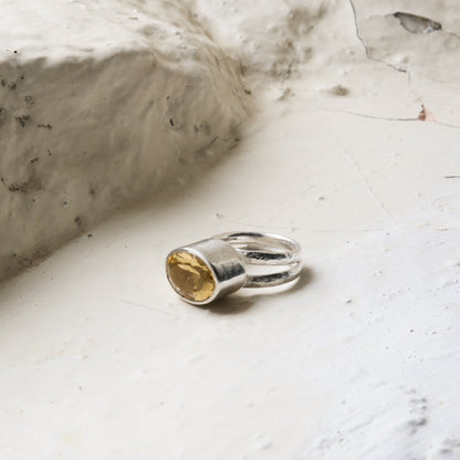 Citrine and silver statement ring picture on a rustic white background.