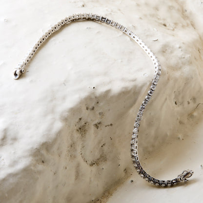 diamond tennis bracelet pictured on white brick in the Cotswold's. Handmade fine jewellery by Madeleine.