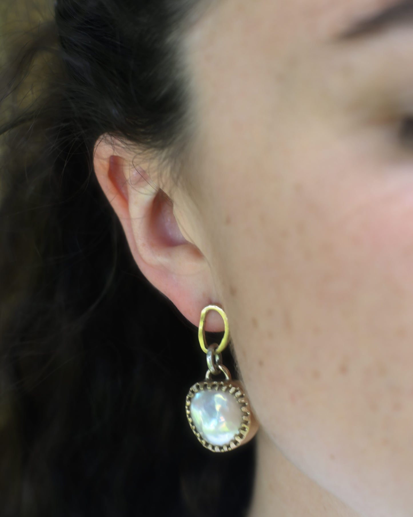 young pretty women wearing big statement pearl earrings.