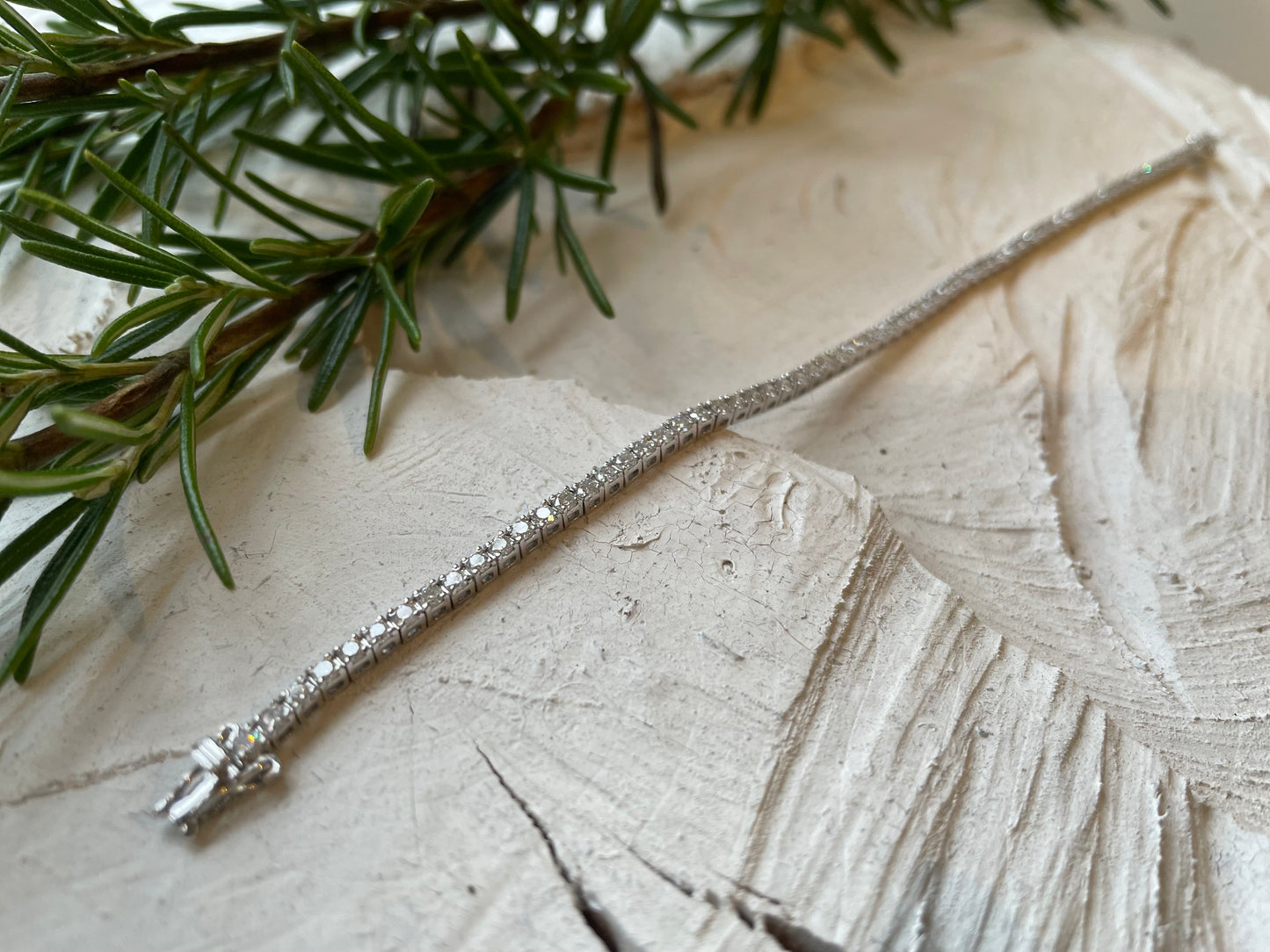 diamond tennis bracelet pictured on white wood in the Cotswold's. Handmade fine jewellery by Madeleine.