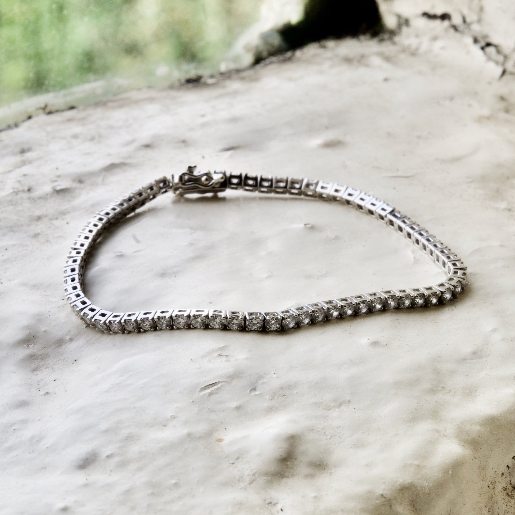 diamond tennis bracelet pictured on white brick in the Cotswold's. Handmade fine jewellery by Madeleine.